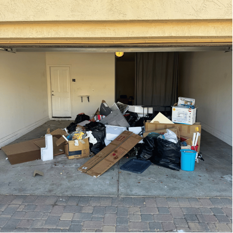 Garage piled with cardboard boxes, trash bags, and household junk in Scottsdale, AZ