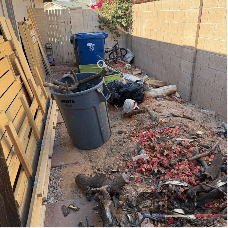 Side yard cluttered with debris, broken wood, and trash bins in Mesa, AZ